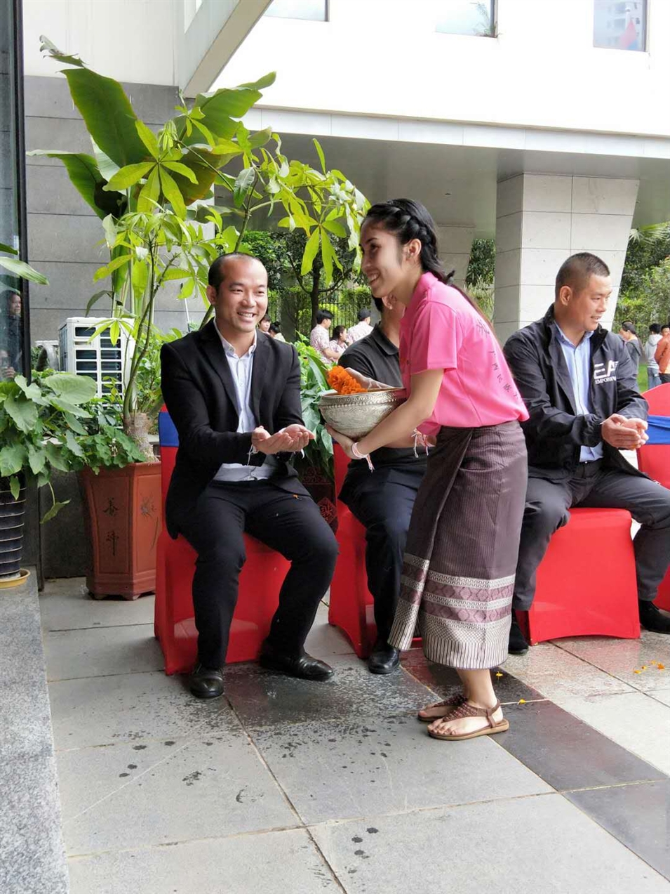老撾駐廣西留學(xué)生代表將浸有花瓣的香水灑客人的手上，表示對嘉賓的美好祝福（圖一）