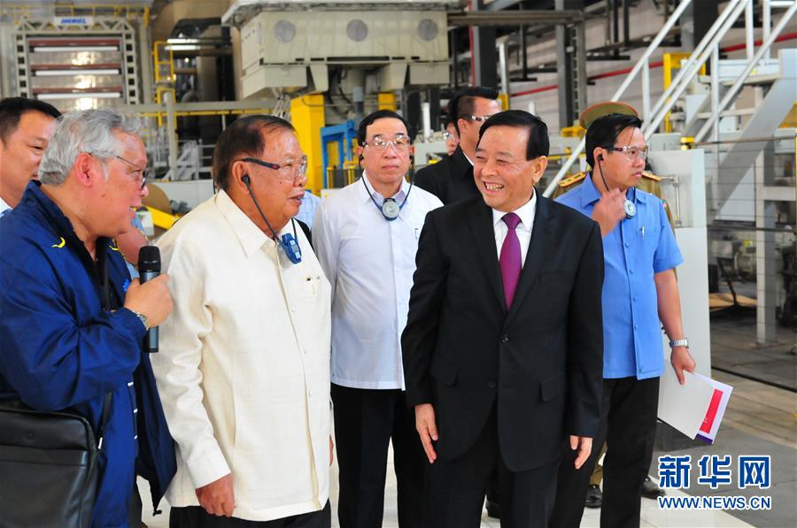3月10日，在老撾沙灣拿吉省車邦縣，老撾人民革命黨中央總書(shū)記、國(guó)家主席本揚(yáng)（左二）在山東太陽(yáng)紙業(yè)股份有限公司董事長(zhǎng)李洪信（右二）的陪同下視察公司。 新華社記者章建華攝